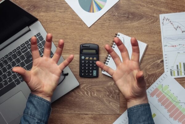 frustrated hands over calculator and metrics