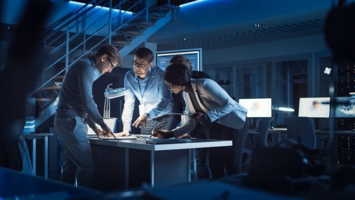 nightime workers hunched over workbench