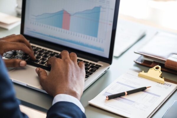 accountant hands checking line graph with invoices to his right