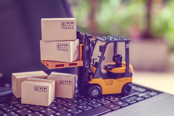 mini forklift carrying boxes on top of laptop computer