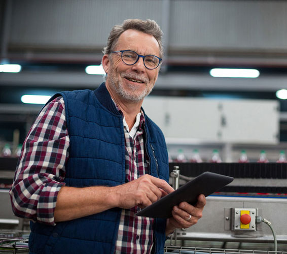 smiling floor manager checking tablet in front of machine