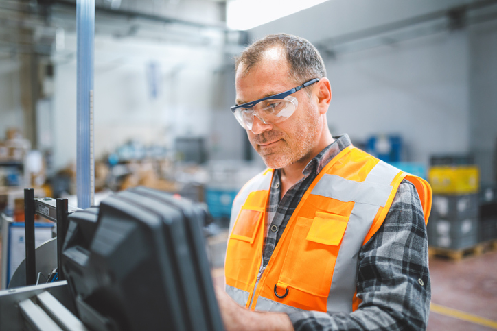 manufacturer with glasses looking at screen