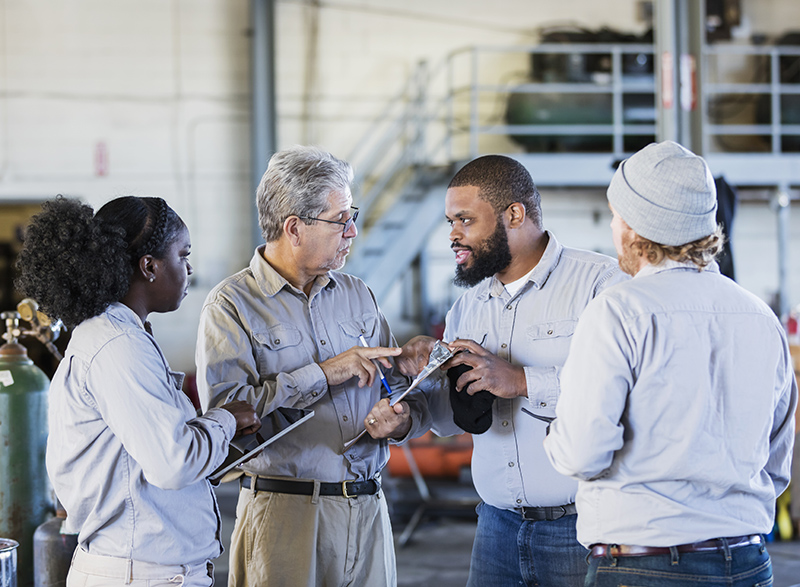 Workers in repair shop having a meeting